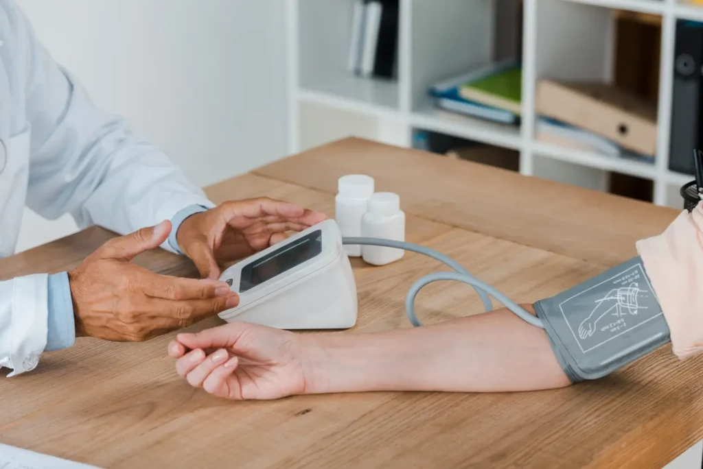 Qué es la presión arterial, síntomas, causas y su tratamiento 1 presión arterial Persona tomándose la presión arterial con un tensiómetro digital – presión arterial.